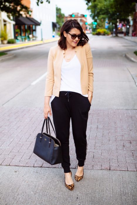 mujer de pantalon negro en la calle con lentes 