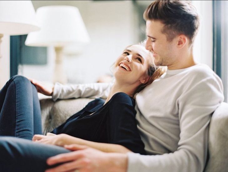 Pareja de novios conversando en una sala 