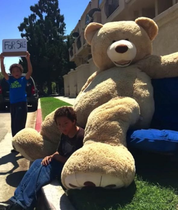 Niños vendiendo oso gigante