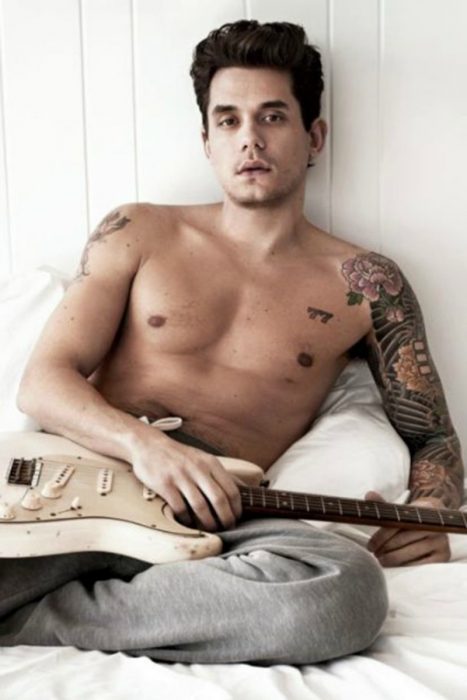 hombre con tatuajes y guitarra