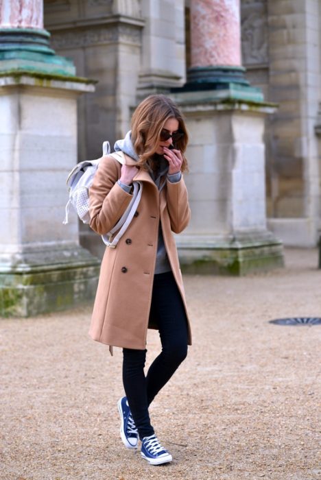 mujer con abrigo cafe y tenis converse 