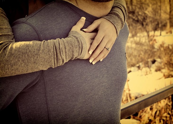 manos de chica abrazando a un hombre