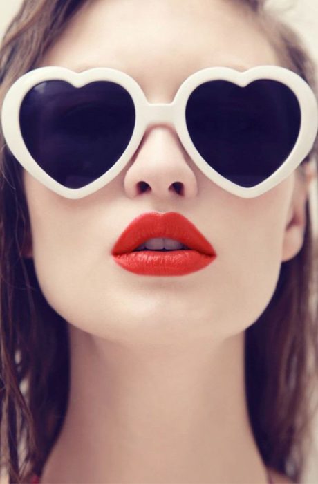 chica con labios rojos y lentes con forma de corazón