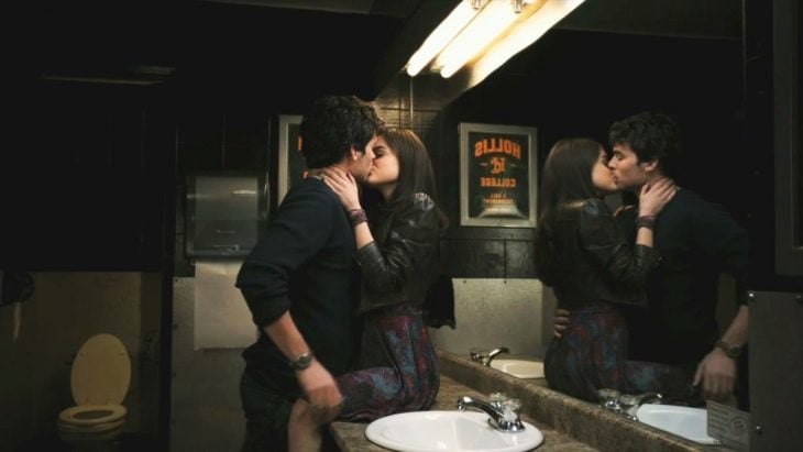 pareja besándose en baño de bar 