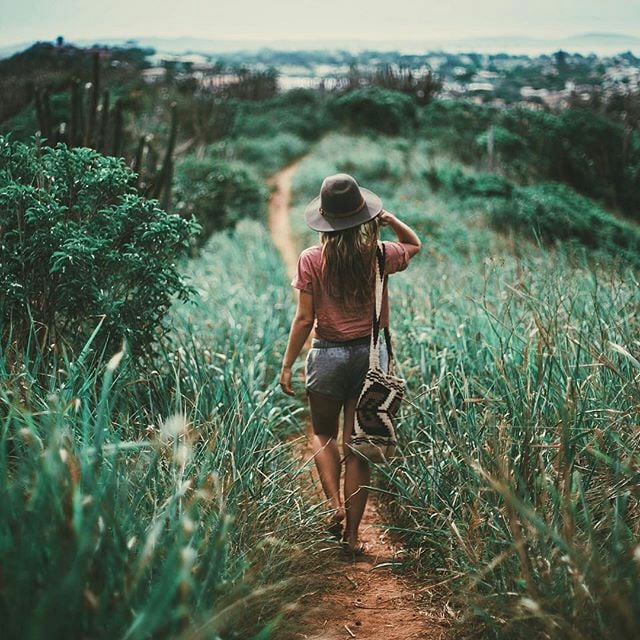Chica caminando por una pradera 
