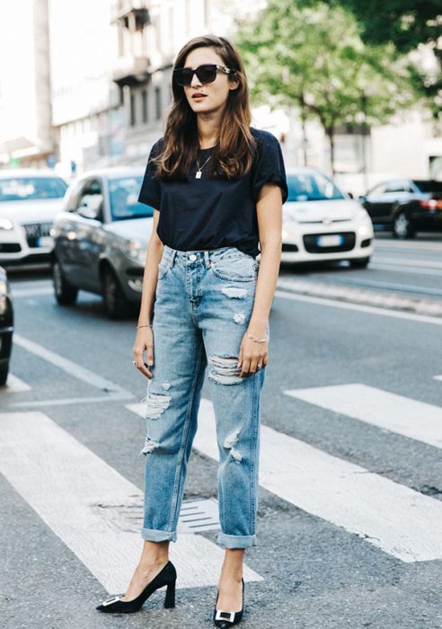 mujer con pantalones rotos y tacones negros 