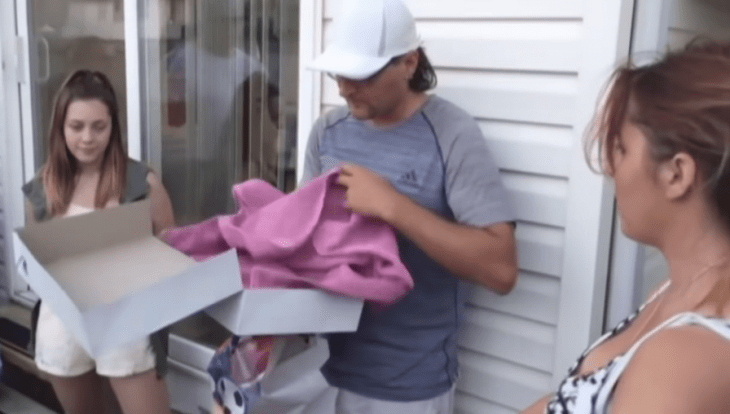 Hombre con playera abre regalo 