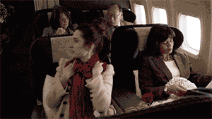 Actriz se reclina en el asiento de un tren. 