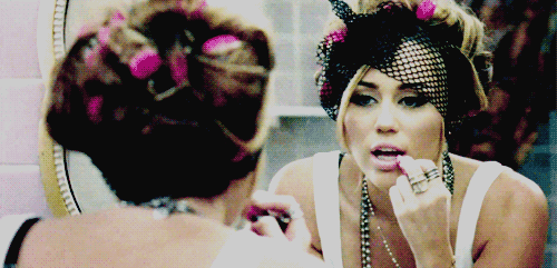 Miley Cirus pintándose los labios. 