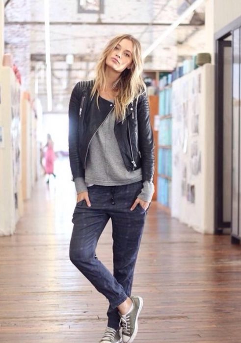 mujer rubia con pantalon negro y chamarra de piel 