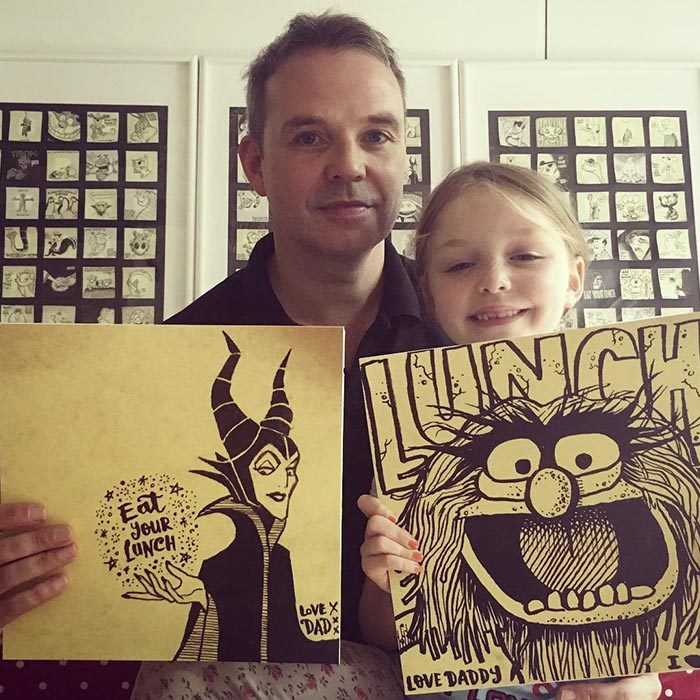 Padre e hija mostrando los dibujos que él hace para ella 