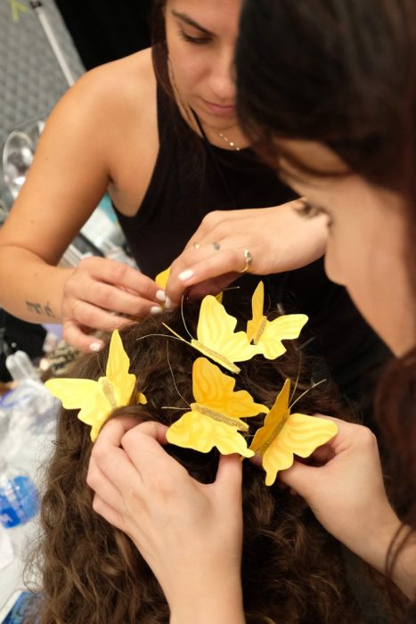 Equipo de maquillaje colocando la corona de mariposas. 