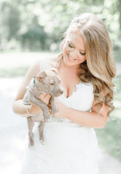 La novia sosteniendo un pit bull. 