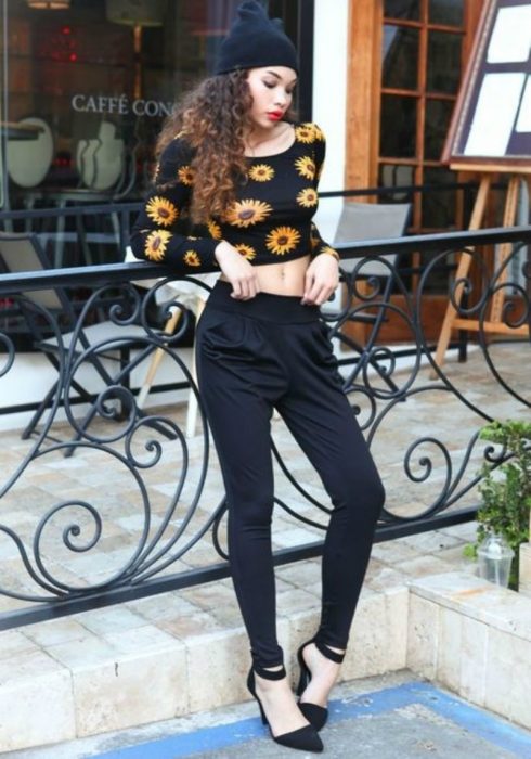 mujer pantalón negro y top de flores 