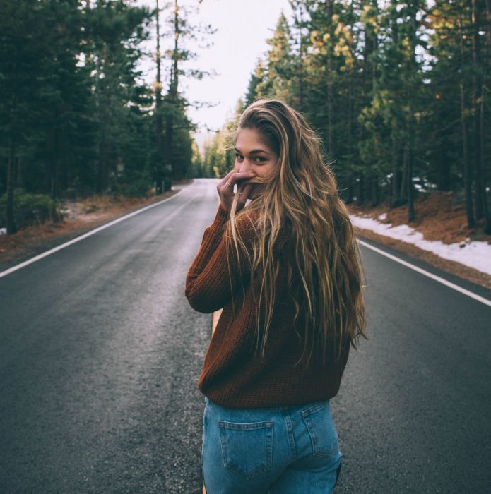 mujer rubia caminando en carretera 