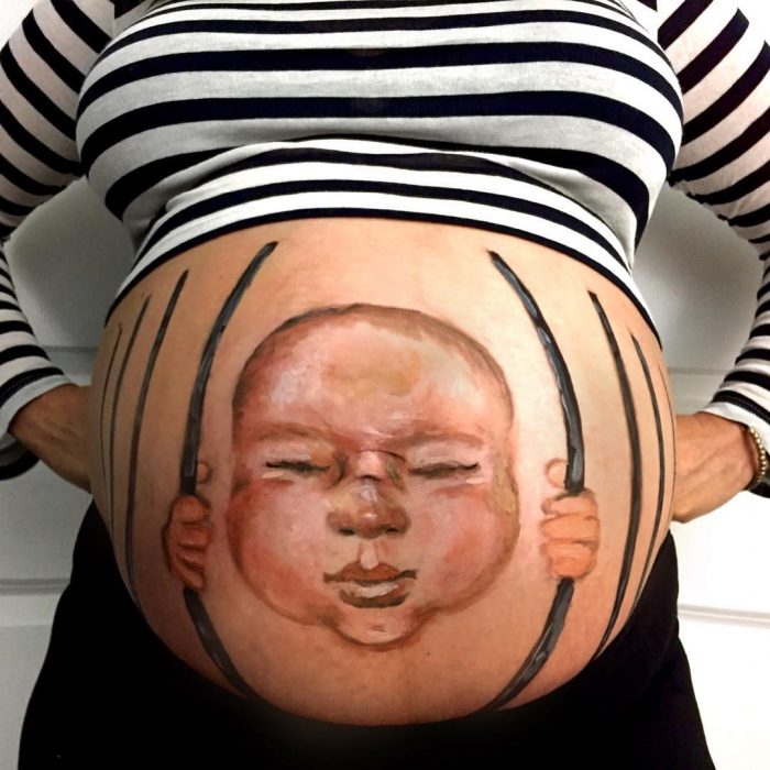 mujer embarazada con pintura de bebe en su vientre