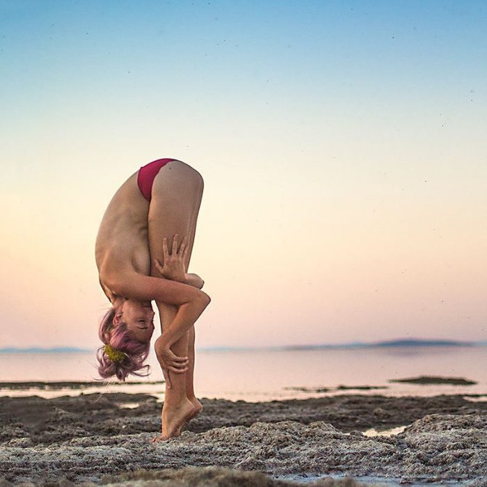 mujer en la playa haciendo yoga 