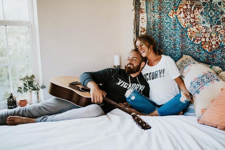 Pareja recostados en la cama. 