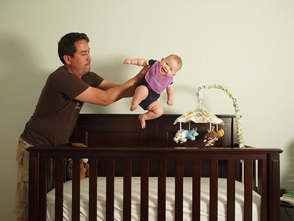 papá sosteniendo bebé sobre cuna