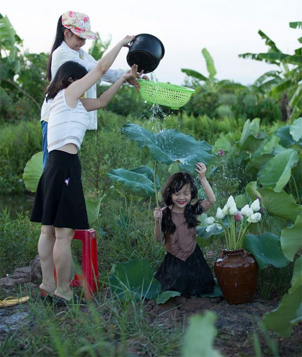 mujeres echan agua encima de hoja para foto