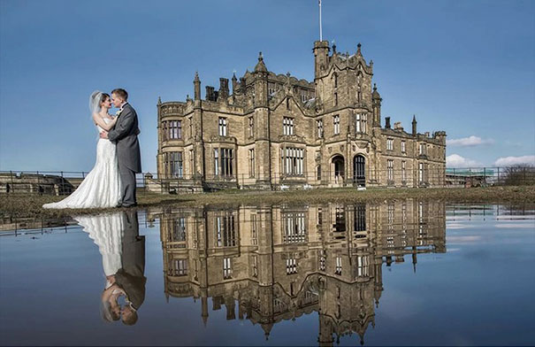 novios besándose frente a castillo