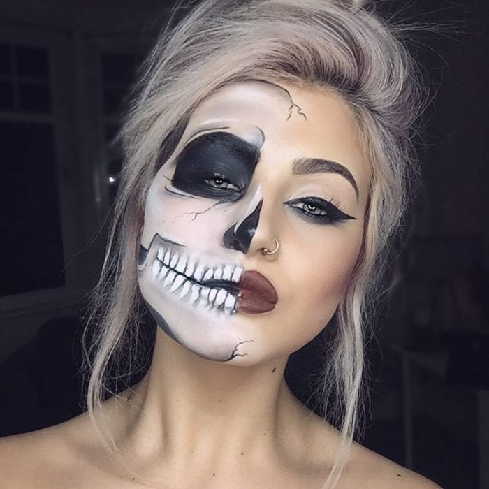 mujer rubia con la mitad de la cara pintada de esqueleto