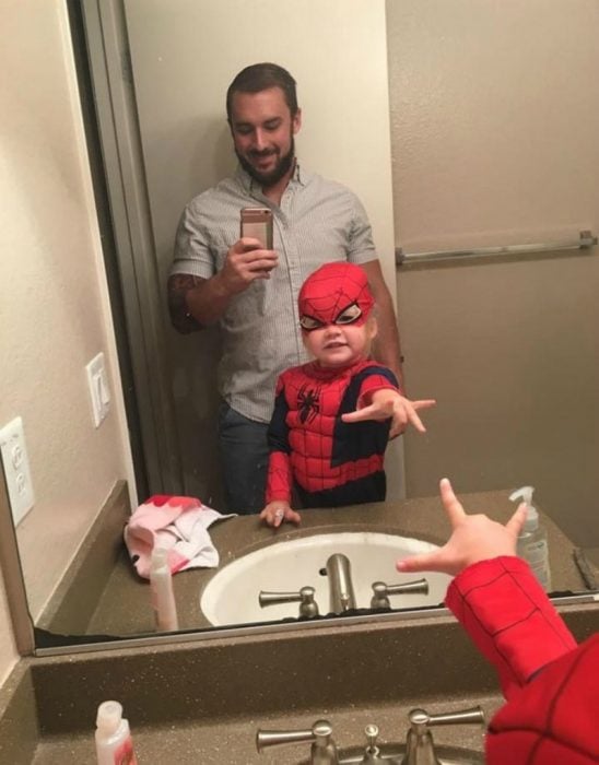 niña con disfraz de hombre araña frente al espejo 