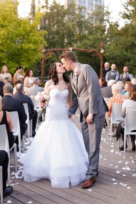 Los novios besándose en la ceremonia. 