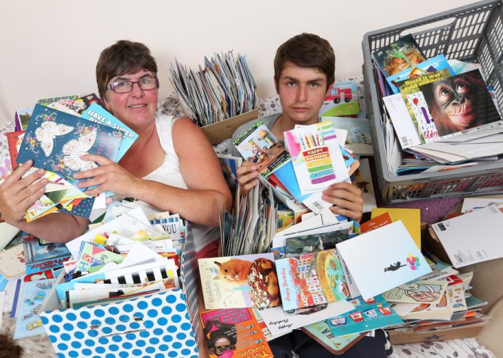 Chico junto con su madre rodeado de cartas de felicitación 