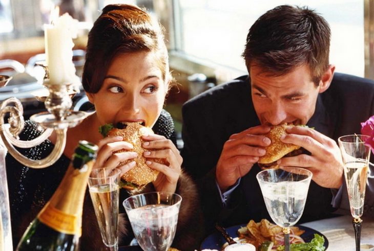 Pareja comiendo hamburguesa. 