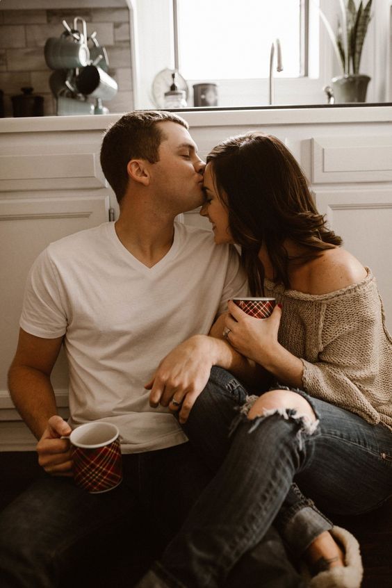 Pareja de novios sentados en la cocina tomando café 