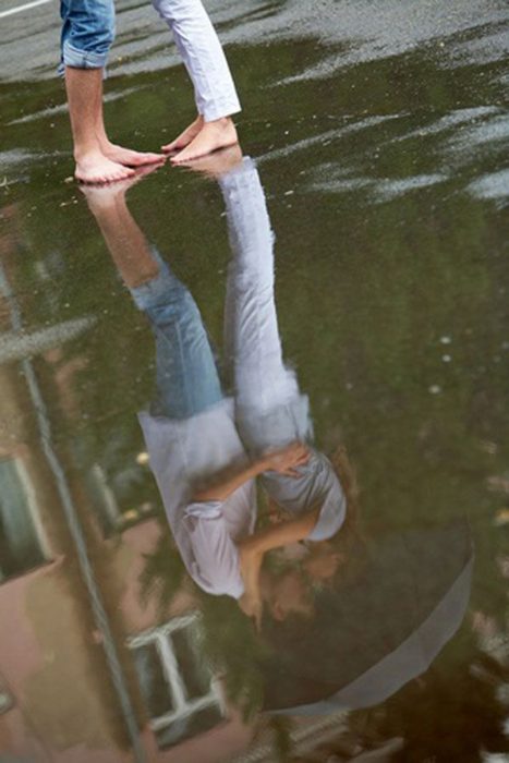 Pareja reflejada en un charco. 