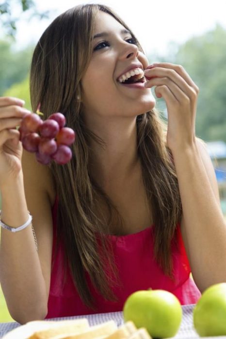 Muchacha comiendo uvas.