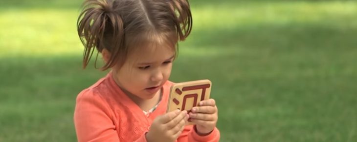 La niña mirando una letra del alfabeto en otro idioma. 