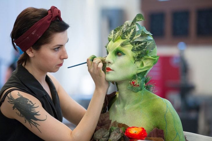 mujer maquillando personaje verde