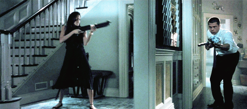 Angelina disparando a Brad a través de una puerta. 