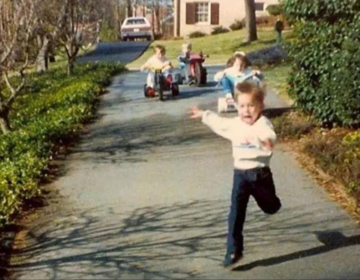 Foto de tres niños corriendo tras su hermano. 