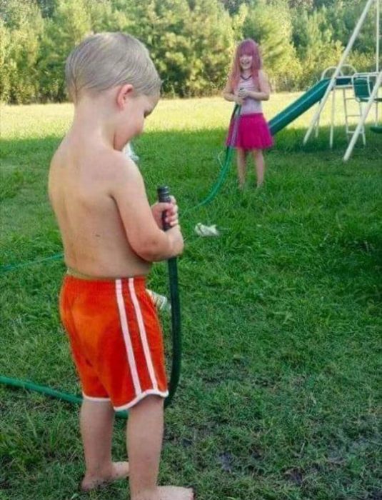 Foto de una niña haciéndole travesuras a un niño. 