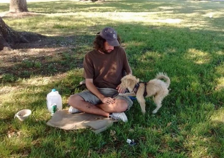 hombre con gorra y perro en el pasto 