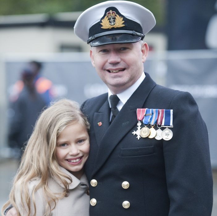 hombre militar abrazando a niña rubia 