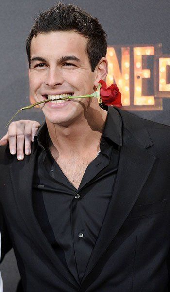 Mario casas con una flor en la boca. 