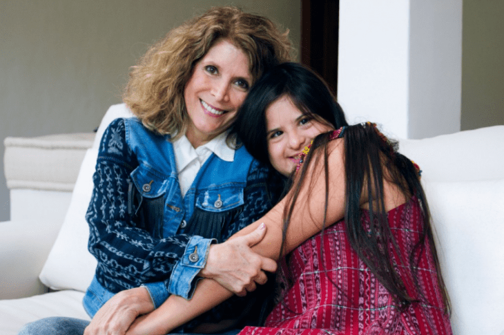 Isabella junto a su mamá, sonriendo. 