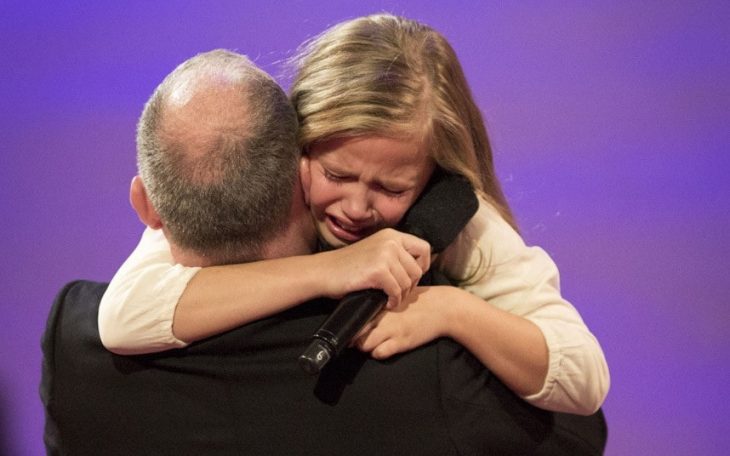 niña rubia abrazando a hombre 