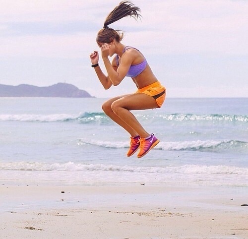 Muchacha saltando en la playa. 