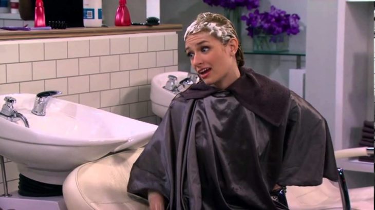 Escena de la serie two broke girls chica con el cabello lleno de espuma en el salón de belleza 