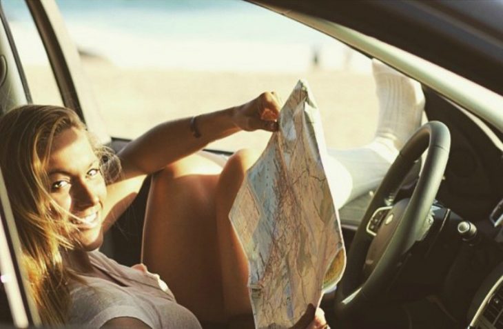 mujer rubia en camioneta con mapa 