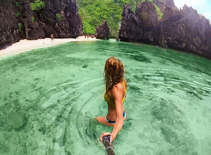 chica rubia en el agua entre montañas 