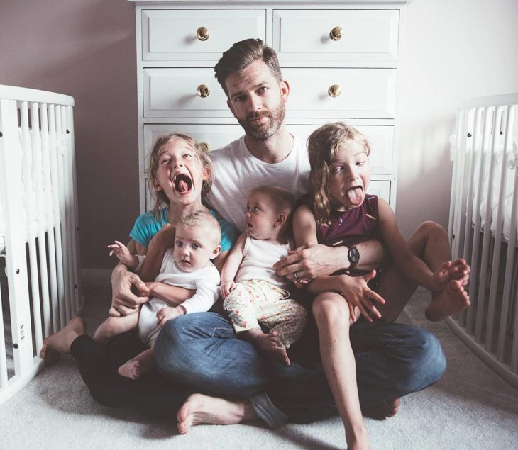 padre junto a niñas riendo 