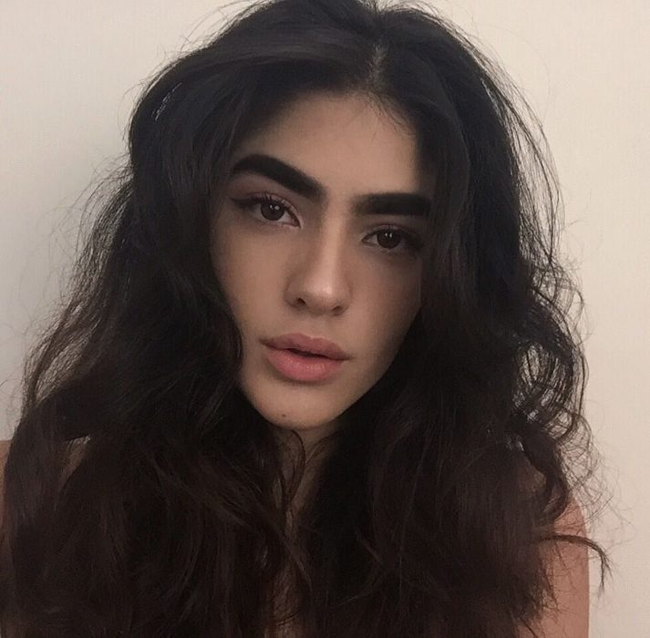 mujer de cabello largo con cejas grandes 