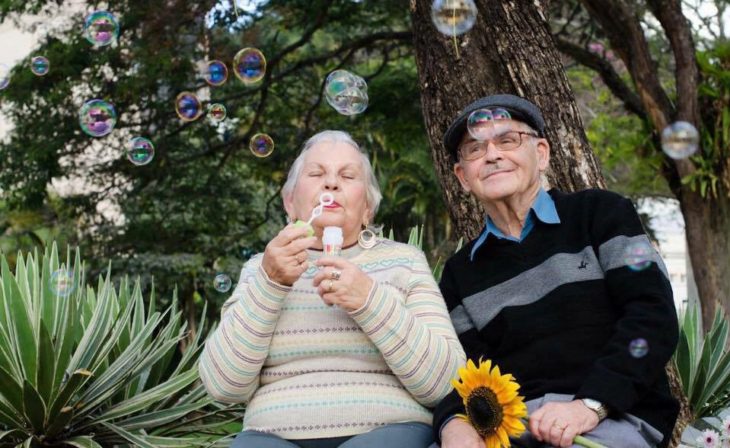 hombre y mujer jugando con burbujas y una flor